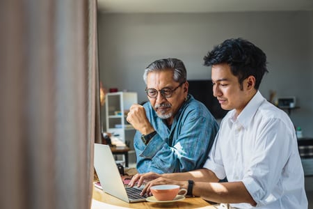 Father and son on computer at desk