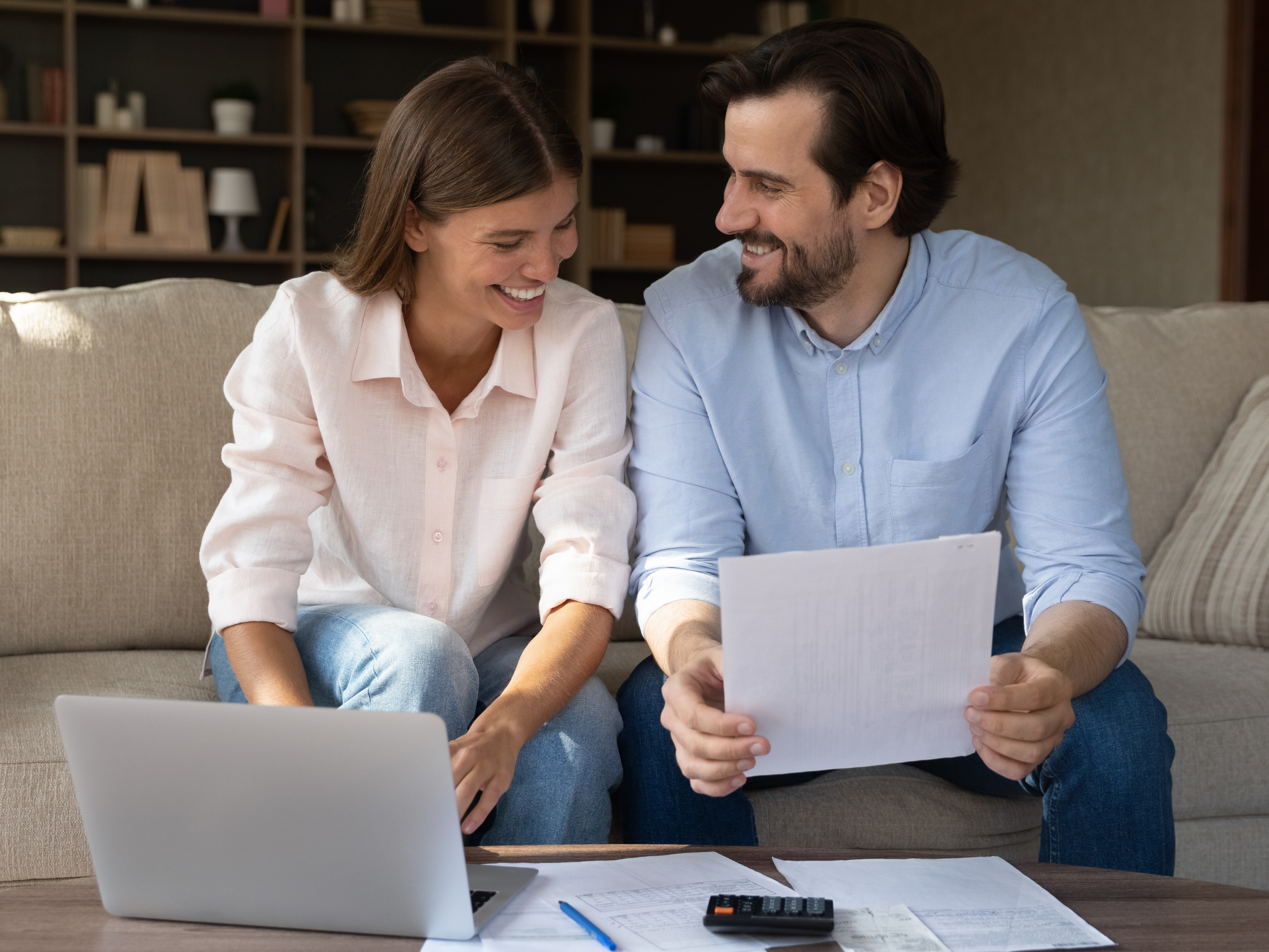 Couple smiling working on computer