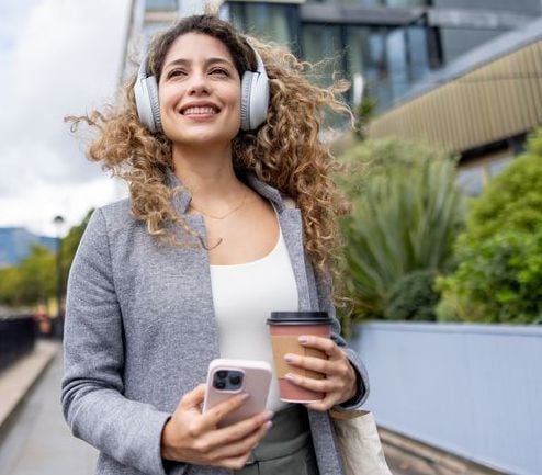 biz woman with coffee listening to podcast